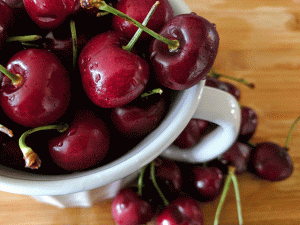 cherries in a bowl on a cutting board