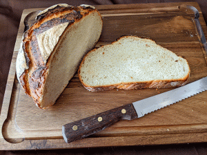 sourdough discard bread sliced on cutting board with knife