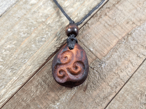 hand-carved avocado stone necklace with triskele