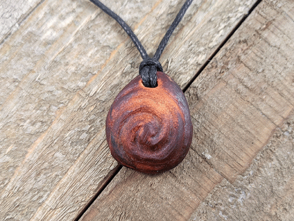 Hand-carved avocado stone necklace with double spiral