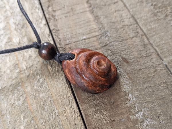 hand-carved avocado stone necklace with bullseye pattern