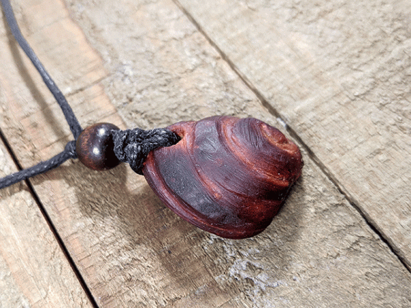 hand-carved avocado stone necklace with spiral pattern