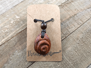 hand-carved avocado stone necklace with bullseye pattern
