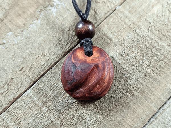 hand-carved avocado stone necklace with triple slash pattern