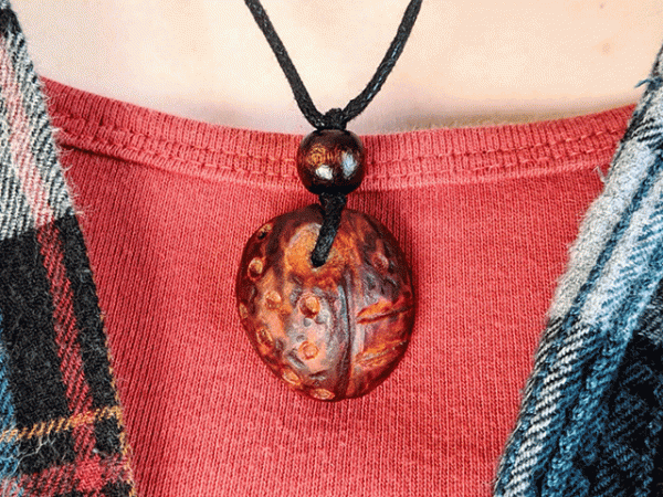 hand-carved avocado stone necklace with tribal pattern