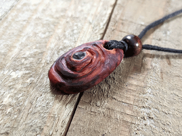 hand-carved avocado stone necklace with red garnet gemstone