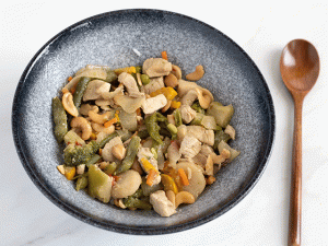 Chris' Cashew Chicken in a blue bowl with a spoon