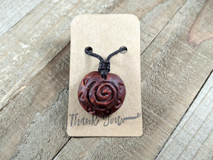 hand-carved avocado stone necklace with sun spiral