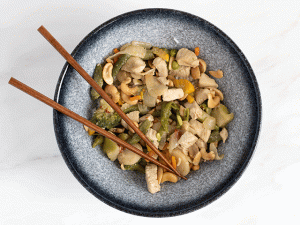Chris' Cashew Chicken in a blue bowl with chopsticks
